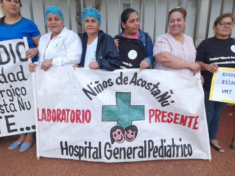 Trabajadores de blanco protestan frente al Hospital Pediátrico Niños de Acosta Ñu, para exigir equidad salarial y pago por insalubridad.