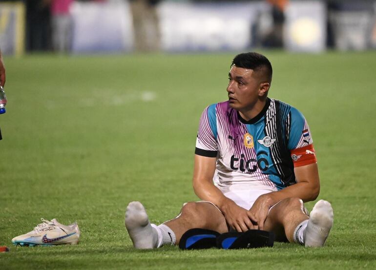 Óscar Cardozo, futbolista de Libertad, sentado al final de un partido del fútbol paraguayo ante Sportivo Luqueño en el estadio Feliciano Cáceres, en Luque.