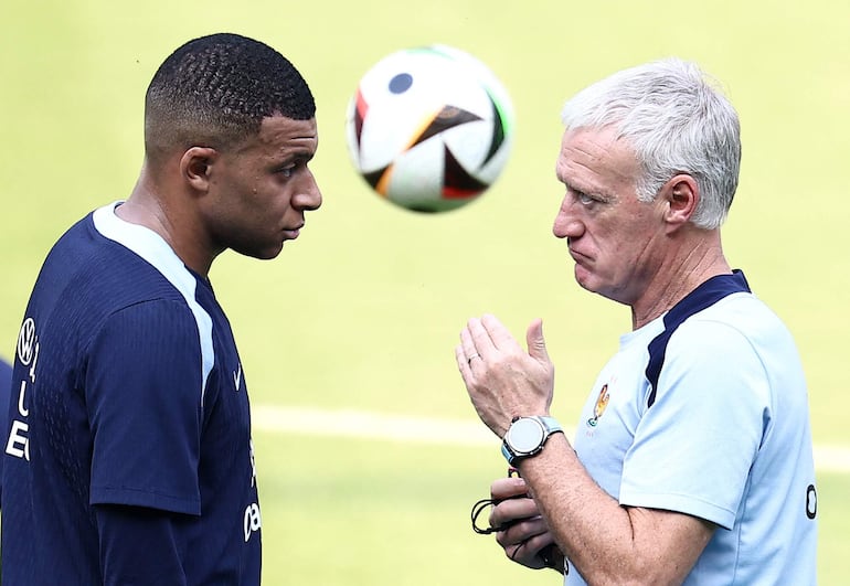 France's forward #10 Kylian Mbappe (L) speaks with France's head coach Didier Deschamps during a training session at the Home Deluxe Arena Stadium in Paderborn, western Germany, on June 27, 2024, during the UEFA EURO 2024 football competition. (Photo by FRANCK FIFE / AFP)