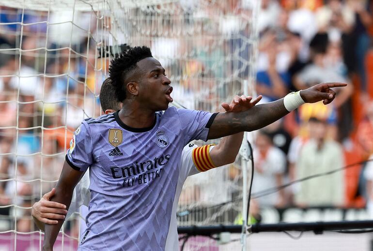 (FILES) Real Madrid's Brazilian forward Vinicius Junior reacts to being insulted pointing at the stands during the Spanish league football match between Valencia CF and Real Madrid CF at the Mestalla stadium in Valencia on May 21, 2023. Three Valencia's supporters have been handed eight-month jail terms for racist insults against Real Madrid's Brazilian forward Vinicius Junior in May 2023, which sparked a wave of international outrage, AFP reports on June 10, 2024. (Photo by JOSE JORDAN / AFP)