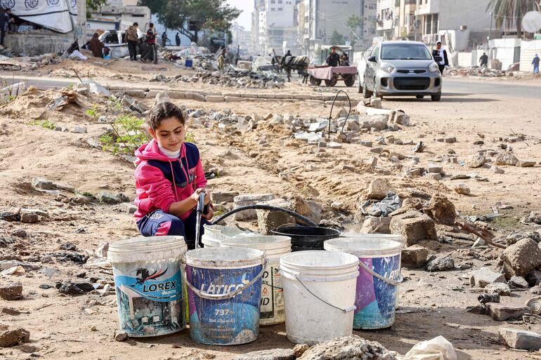 Una niña llena baldes con agua en la Ciudad de Gaza, el pasado 11 de diciembre.