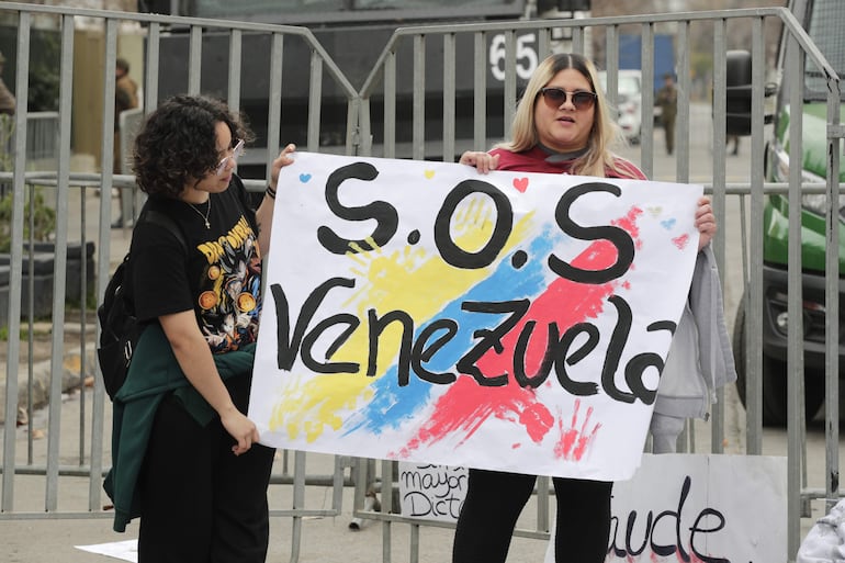 Ciudadanas venezolanos sostienen carteles