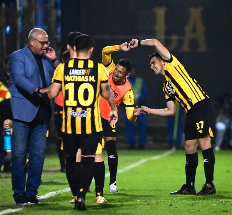 Francisco Arce conversa con sus jugadores, mientras Estivel Moreira y Daniel Pérez celebran el tanto del aurinegro.