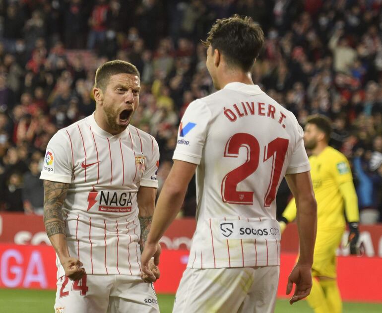 El argentino Alejandro "Papu" Gómez (i), jugador del Sevilla, celebra con Oliver Torres un gol en el partido ante el Granada durante el partido de Liga en Primera División en el estadio Ramón Sánchez-Pizjúan, en Sevilla.
