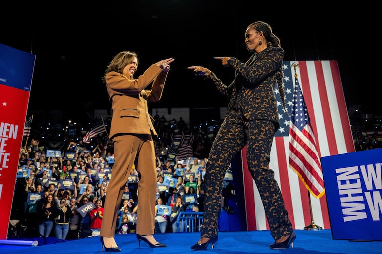 La candidata presidencial demócrata, la vicepresidenta estadounidense Kamala Harris, saluda a la ex primera dama Michelle Obama durante un mitin de campaña en el Wings Event Center este 26 de octubre de 2024 en Kalamazoo, Michigan.