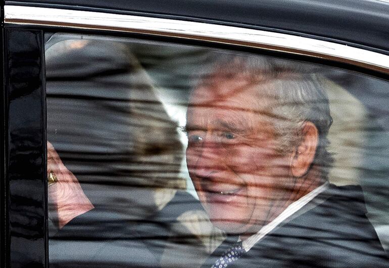 El rey Carlos III saludando desde su automóvil. (HENRY NICHOLLS / AFP)