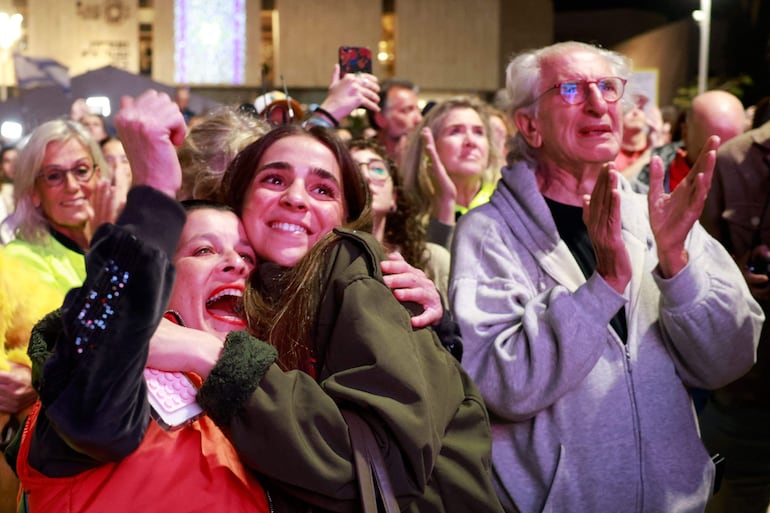 Familiares y amigos de las rehenes liberadas festejan mientras ven una trasmisión de su liberación.