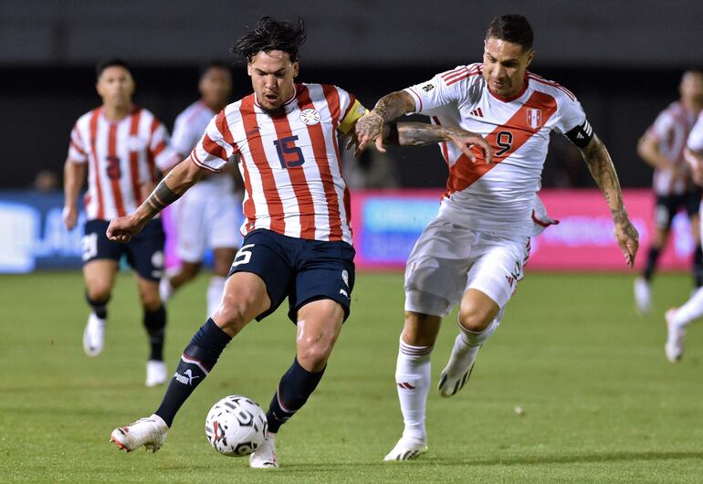 Paolo Guerrero (d) disputa el balón con Gustavo Gómez, durante el partido de anoche entre Perú y Paraguay.