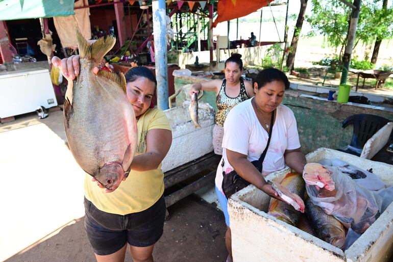 Pescadera de Remanso sostiene un ejemplar de Pacú, que ofrece en la tradicional pescadería en la zona del Puente.