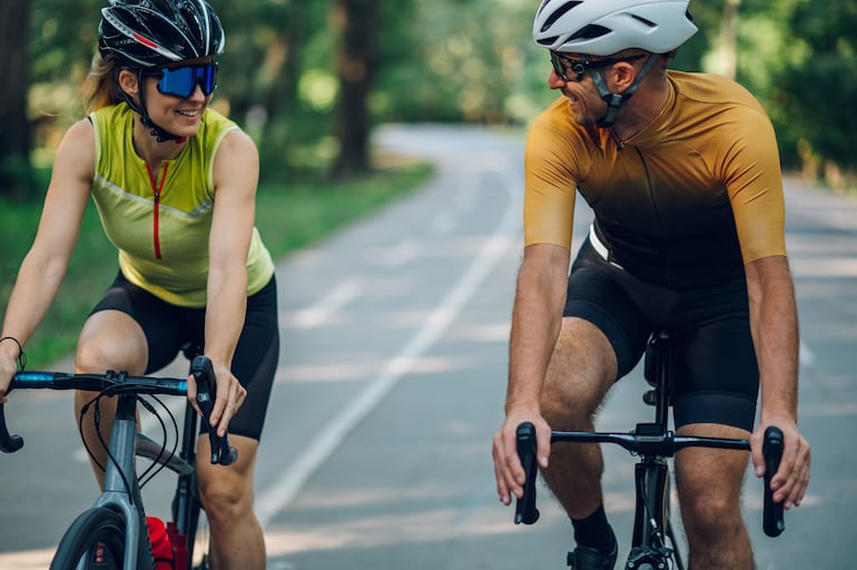 Una mujer y un hombre pedalean sus bicicletas.