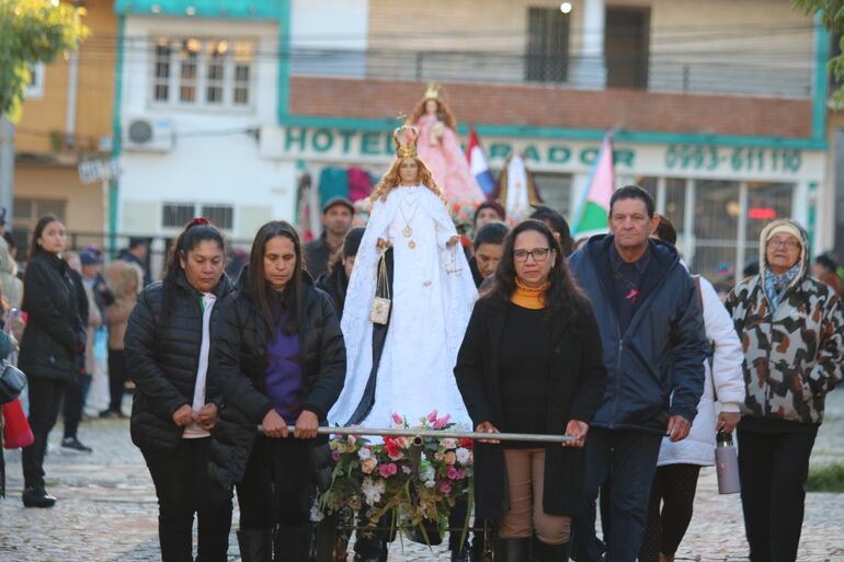 Advocaciones marianas ingresan en fila en adornadas andas sostenidas por fieles católicos. 