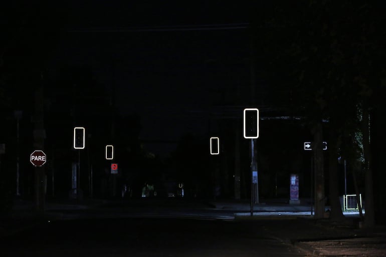 Fotografía de unos semáforos apagados este martes, en Santiago (Chile). Chile se preparaba para pasar una noche sin suministro eléctrico después de que fallaran los tres intentos por reparar el corte de energía ocurrido en la tarde del martes y que afectó al 99 % del país. 
