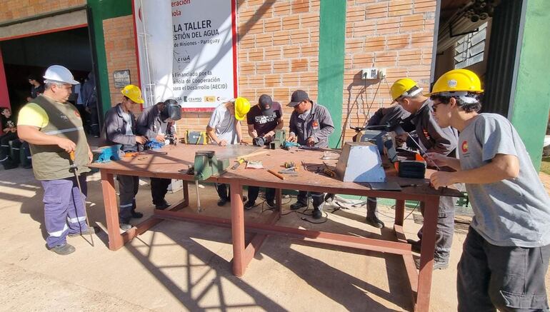 Los jóvenes reviendo instrucciones en el taller de herrería.