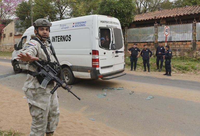 Un fusilero de la FOPE resguarda el móvil de traslado de internos de la penitenciaría regional de Emboscada que fue atacado en la Costanera.