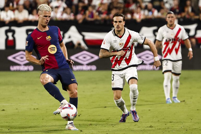 MADRID, 27/08/2024.- El centrocampista del FC Barcelona Dani Olmo (i) controla una posesión durante el partido de la tercera jornada de Liga en Primera División que Rayo Vallecano y FC Barcelona disputan este martes en el estadio de Vallecas, en Madrid. EFE/ Sergio Pérez
