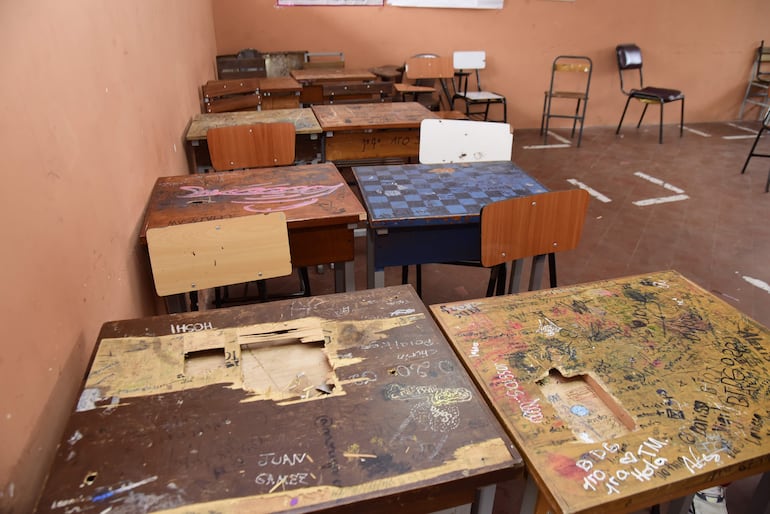 Muebles rotos y paredes sucias y rasgadas en una sala de clases del CNC.