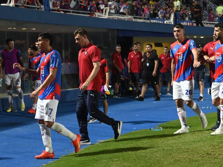 Los jugadores de Cerro Porteño y el entrenador Facundo Sava (c) abandonan el campo de juegos de La Nueva Olla después de la derrota contra Guaireña por la primera fecha del torneo Clausura 2023 del fútbol paraguayo.