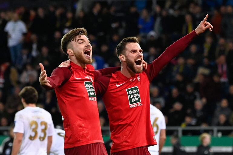 TOPSHOT - Kaiserslautern's German defender #02 Boris Tomiak (R) and Kaiserslautern's German midfielder #16 Julian Niehues celebrate the goal scored by Kaiserslautern's Malian defender #06 Almamy Toure (not pictured) during the German Cup (DFB Pokal) semi-final football match between 1 FC Saarbruecken and 1 FC Kaiserslautern at the Ludwigsparkstadion in Saarbruecken, western Germany on April 2, 2024. (Photo by Jean-Christophe VERHAEGEN / AFP) / DFB REGULATIONS PROHIBIT ANY USE OF PHOTOGRAPHS AS IMAGE SEQUENCES AND QUASI-VIDEO.