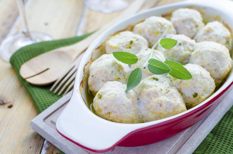 Bolitas de ricota y espinaca rellenas de pollo con salsa de tomate.