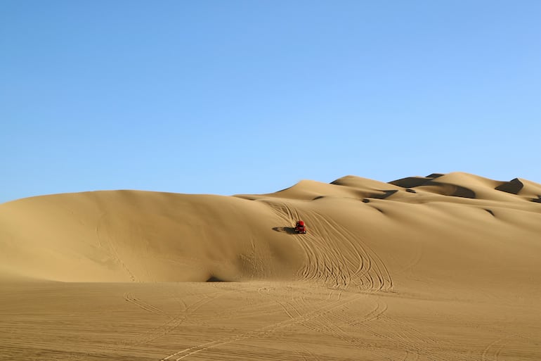 Coche en la inmensa duna de arena de Huacachina, región de Ica, Perú.