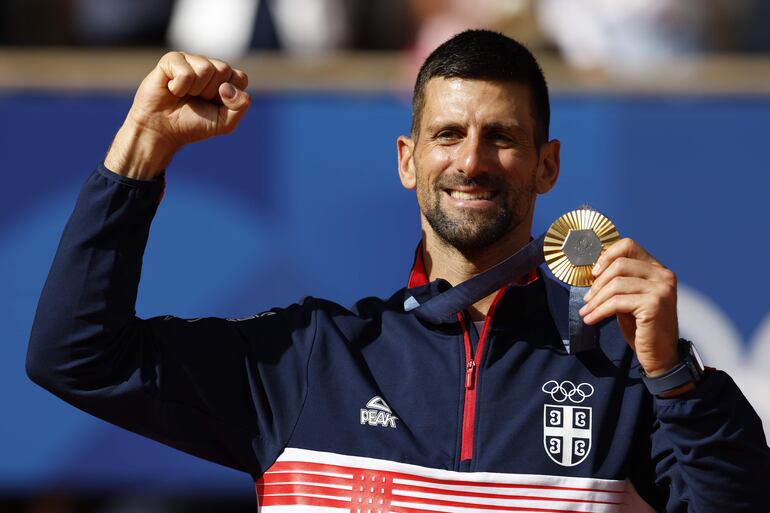 El tenista serbio Novak Djokovic posa con la medalla de oro en el podio tras la final individual masculina de tenis de los Juegos Olímpicos de París 2024 este domingo, en la capital gala.