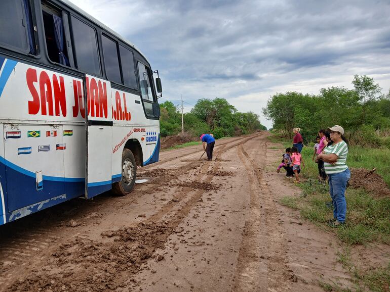 Pasajeros del transporte público en medio del barro tras la pequeña lluvia registrada y que impedía que el ómnibus llegara a Fuerte Olimpo.