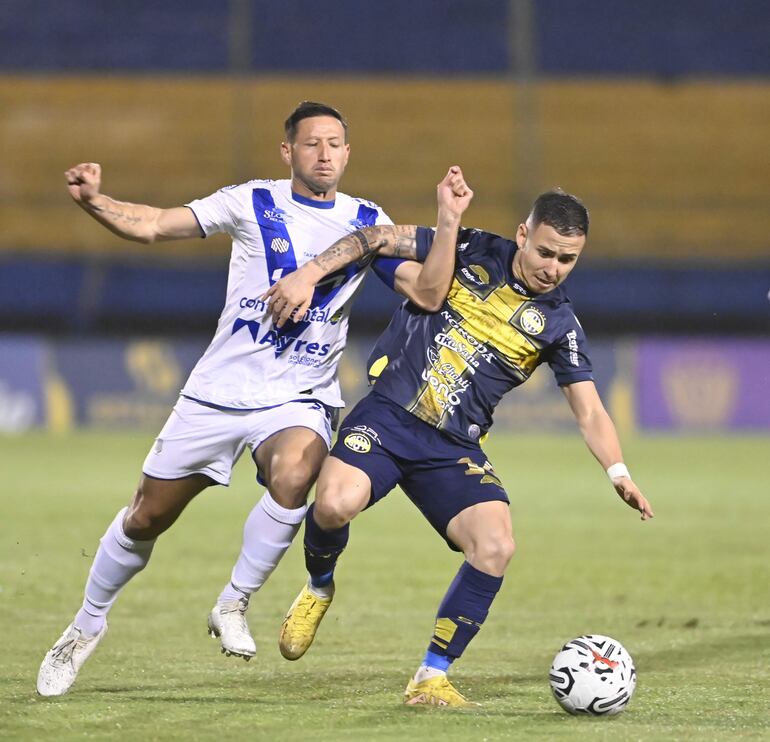 El defensor de Ameliano, Julio González, disputa palmo a palmo con Sergio Mendoza, defensor de Trinidense.