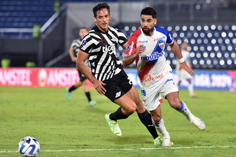 El argentino Emanuel Brítez, futbolista de Fortaleza, pelea por el balón con el paraguayo Roque Santa Cruz, jugador de Libertad, en un partido por los octavos de final de la Copa Sudamericana 2023 en el estadio Defensores del Chaco, en Asunción.