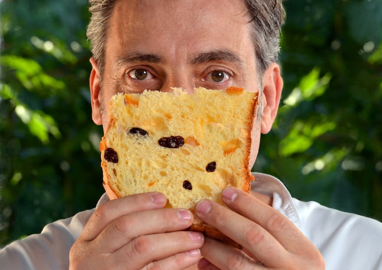 Hombre con una porción de pan dulce en las manos.