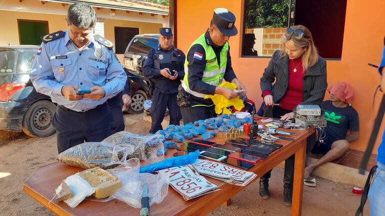 La fiscal Gladys Gonzalez inspecciones las evidencias incautadas tras allanamiento donde residía la banda de robacoches que asaltó a mano armada una playa de autos en Ñemby.