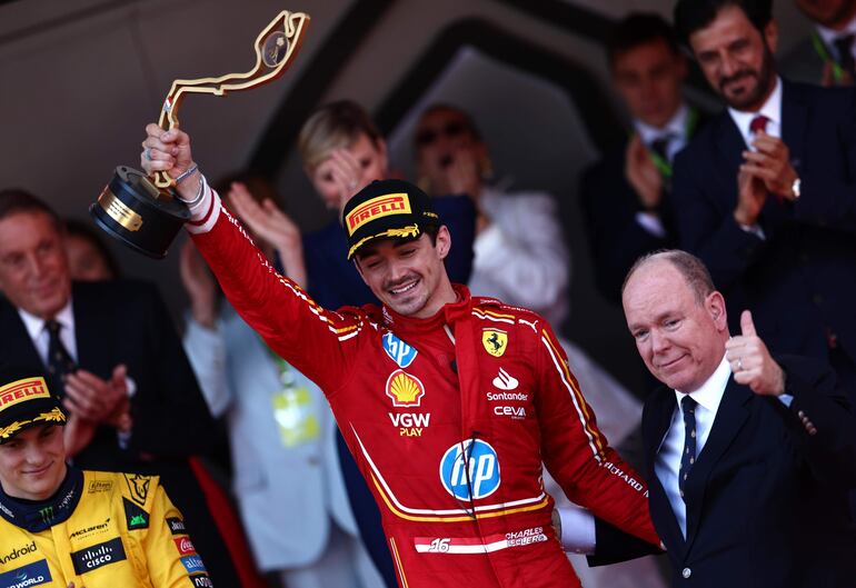 El piloto de Ferrari Charles Leclerc posa en el podio junto al príncipe Alberto de Mónaco tras vencer en el Gran Premio de Mónaco de Fórmula Uno. (EFE/ANNA SZILAGYI)
