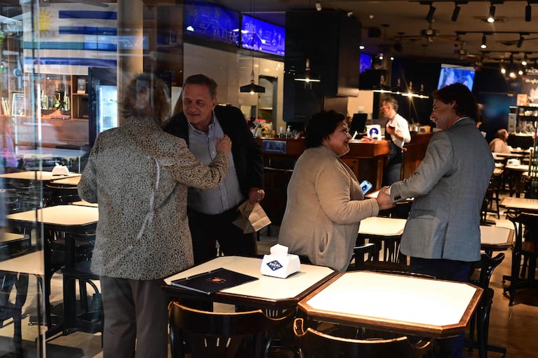 El presidente Luis Lacalle Pou (d) en una cafetería en Montevideo junto al candidato de su partido a la presidencia, Alvaro Delgado (2do de la izq.).