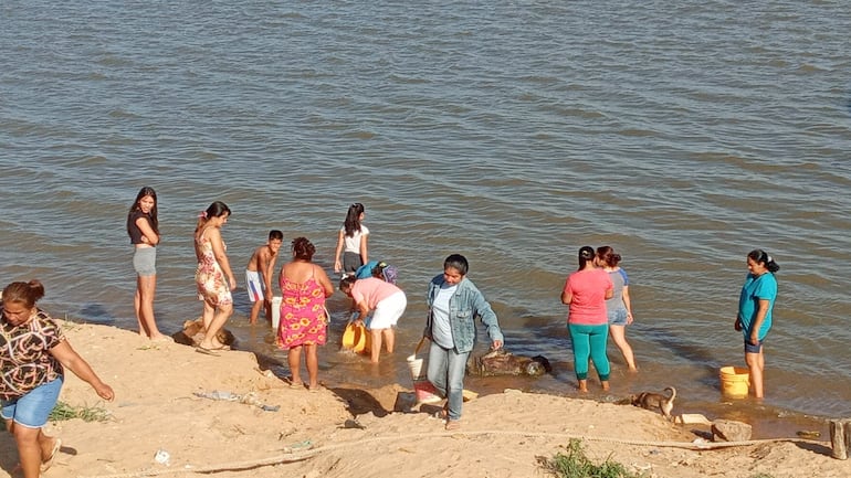 Las vecinas llevan agua del río, ante la ausencia de la ESSAP u otros organismos estatales que les garanticen agua potable.