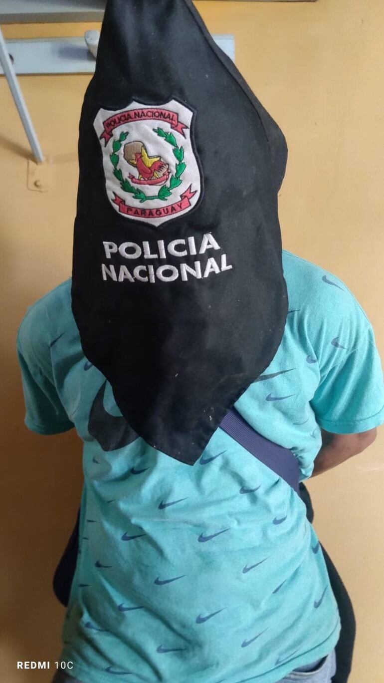 hombre de remera celeste con capucha de la policía nacional