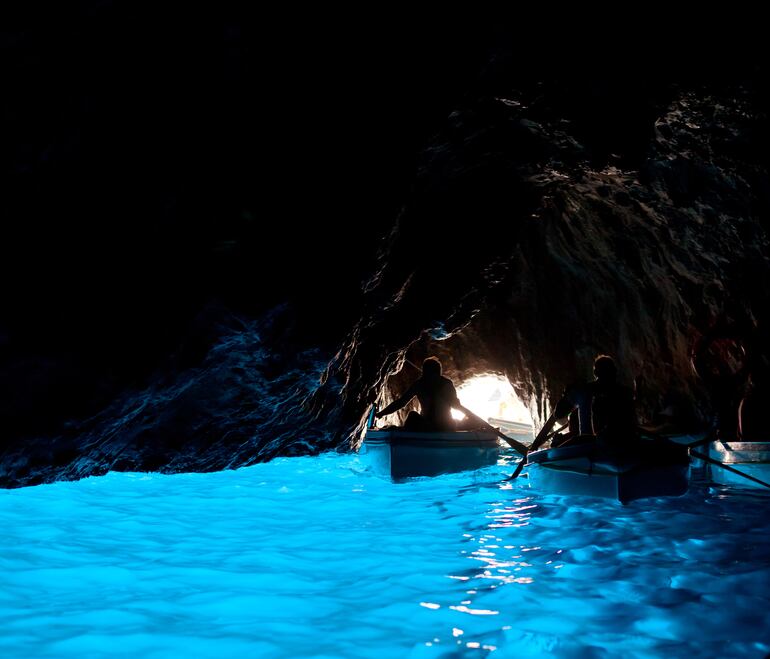 Turistas visitan la Gruta Azul en Capri, Italia.