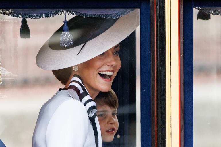 La princesa Kate sonríe radiante desde la carroza, junto a su hijo Luis. 
