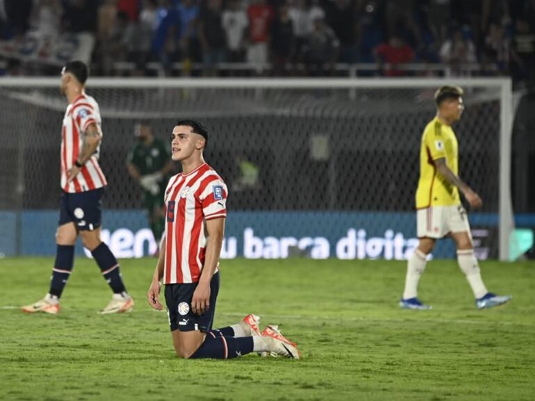 Ramón Sosa, jugador de la selección paraguaya, arrodillado en el campo lamentando la derrota ante Colombia por las Eliminatorias Sudamericanas al Mundial 2026 en el estadio Defensores del Chaco, en Asunción.