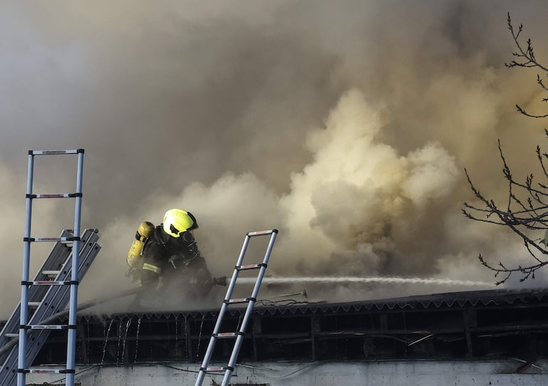 Un bombero intenta apagar un incendio causado por un ataque ruso el jueves en una zona residencial de Kiev.