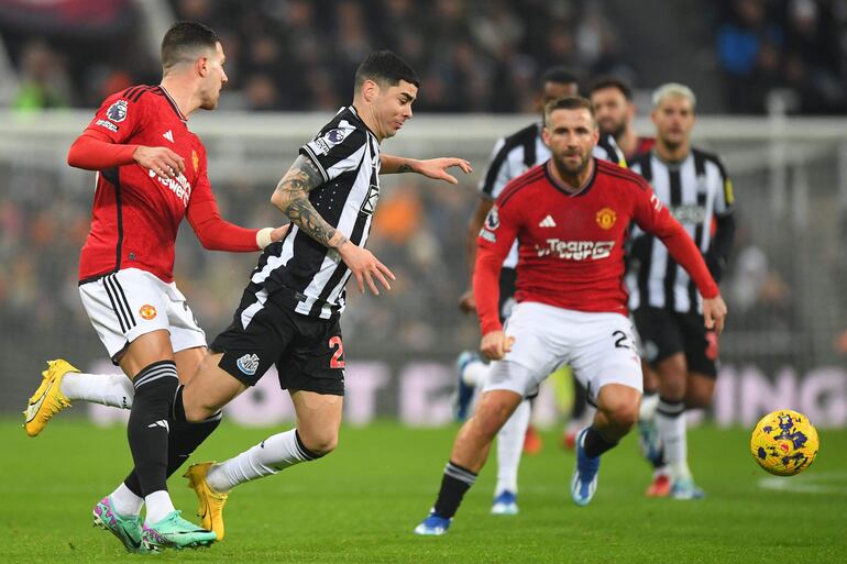 Miguel Almirón intenta escapar de la marca de Diogo Dalot (i) y Luke Shaw, durante el partido que Newcastle derrotó ayer 1-0 al Manchester United.