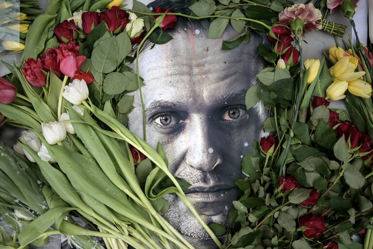 Un retrato de Alexei Navalni cubierto de flores frente al antiguo consulado de Rusia en Frankfurt, Alemania.