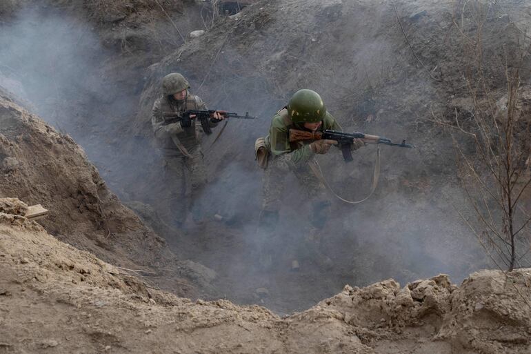 Civiles participan en un entrenamiento de guerra de trincheras durante una "Semana de prueba" organizada por la 3.ª Brigada de Asalto en Kiev en medio de la invasión rusa de Ucrania. 