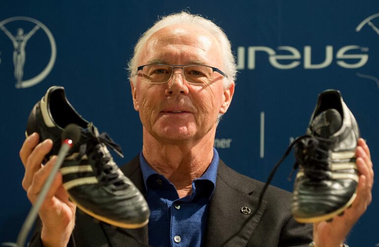 Fotografía de archivo del exfutbolista y entrenador alemán Franz Beckenbauer, sosteniendo a entrenadores de fútbol durante una conferencia de prensa en Stuttgart, Alemania, el 27 de enero de 2013, reeditada el 8 de enero de 2024.