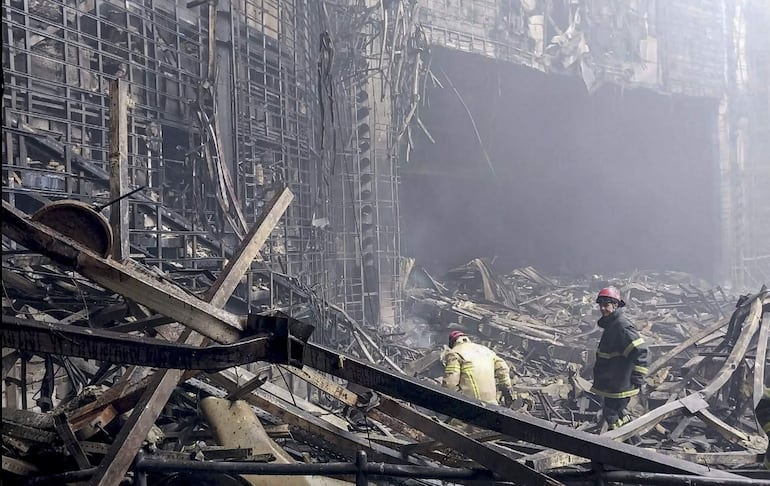 Bomberos trabajan en el salón de conciertos Crocus, en las afueras de Moscú, sitio de un atentado perpetrado el viernes.