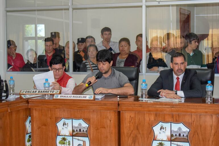 Momento en que el concejal Oscar Américo Barreto le cede su asiento al intendente interino renunciante, José Riquelme, y se sienta a lado del concejal Braulio Riquelme.