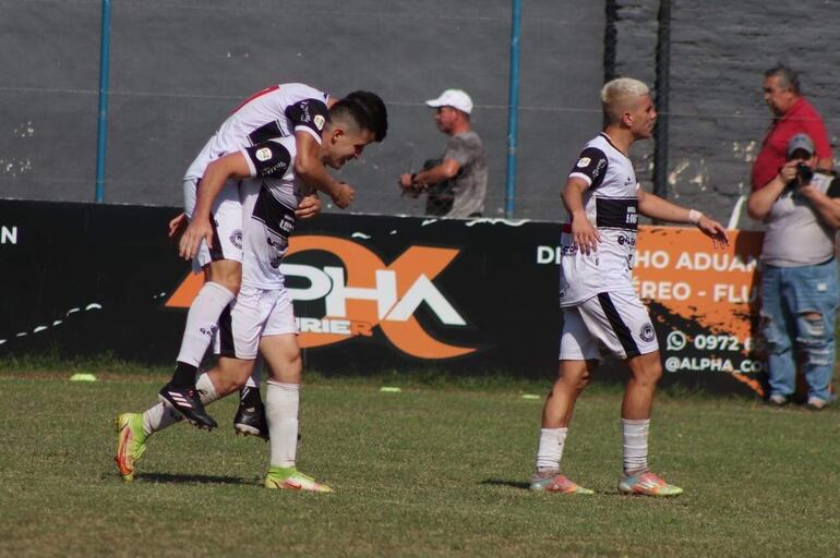 Enmanuel Caballero se trepa al goleador Armando Pessolani, en el tanto de apertura. El argentino  Federico González acompaña el festejo. (Foto: APF)