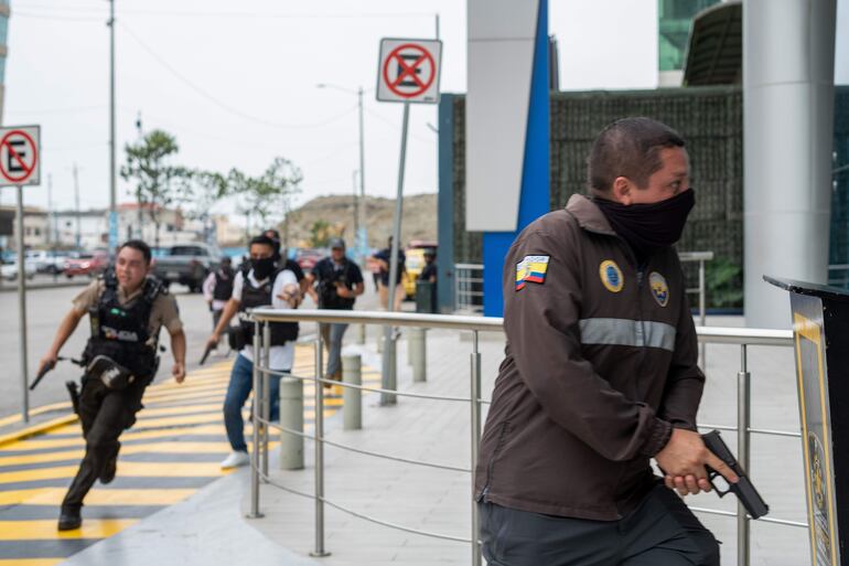 Policías ecuatorianos se movilizan en las inmediaciones del canal televisivo TC, tomado por atacantes armados, el martes en Guayaquil.