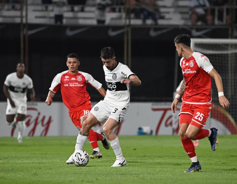 Alejandro Silva, de Olimpia, ante la marca de Marcos Machuca y Juan Saborido.