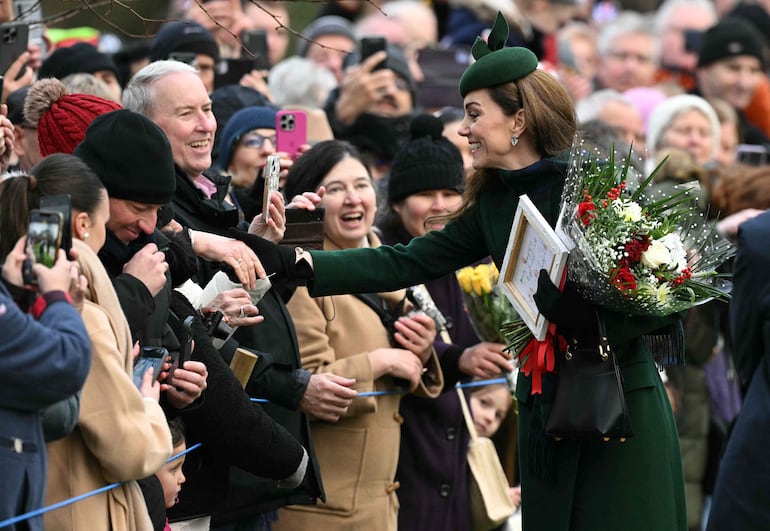 La princesa de Gales saluda a sus simpatizantes después de asistir al tradicional servicio del día de Navidad de la Familia Real en la Iglesia de Santa María Magdalena en Sandringham, Norfolk. (Oli SCARFF / AFP)