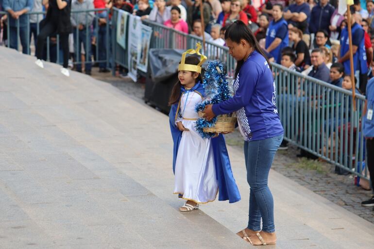 Una niña promesera entrega su ofrenda a la Virgen.
