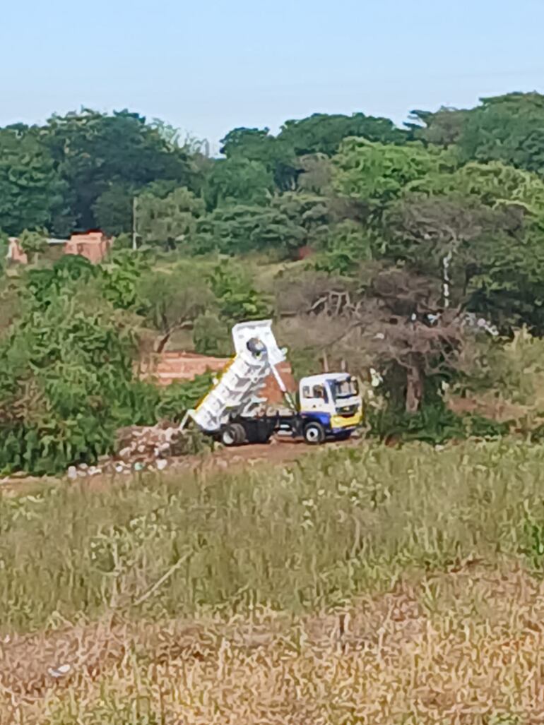 Vecinos de Maramburé captaron el momento que el camión recolector de basura municipal arrojaba los desperdicios en un patio baldío.